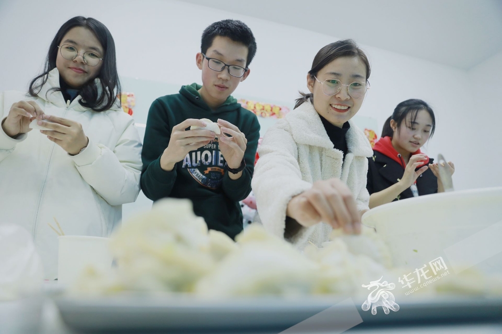 留校学生们正在开开心心的包饺子过春节。华龙网-新重庆客户端 谢鹏 摄