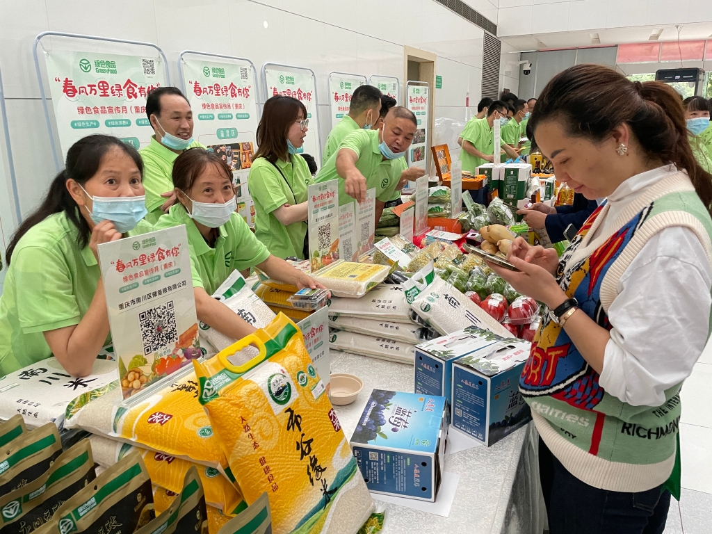 在活动现场，一位消费者正在选购绿色食品产品。华龙网-新重庆客户端记者 赵紫东 摄