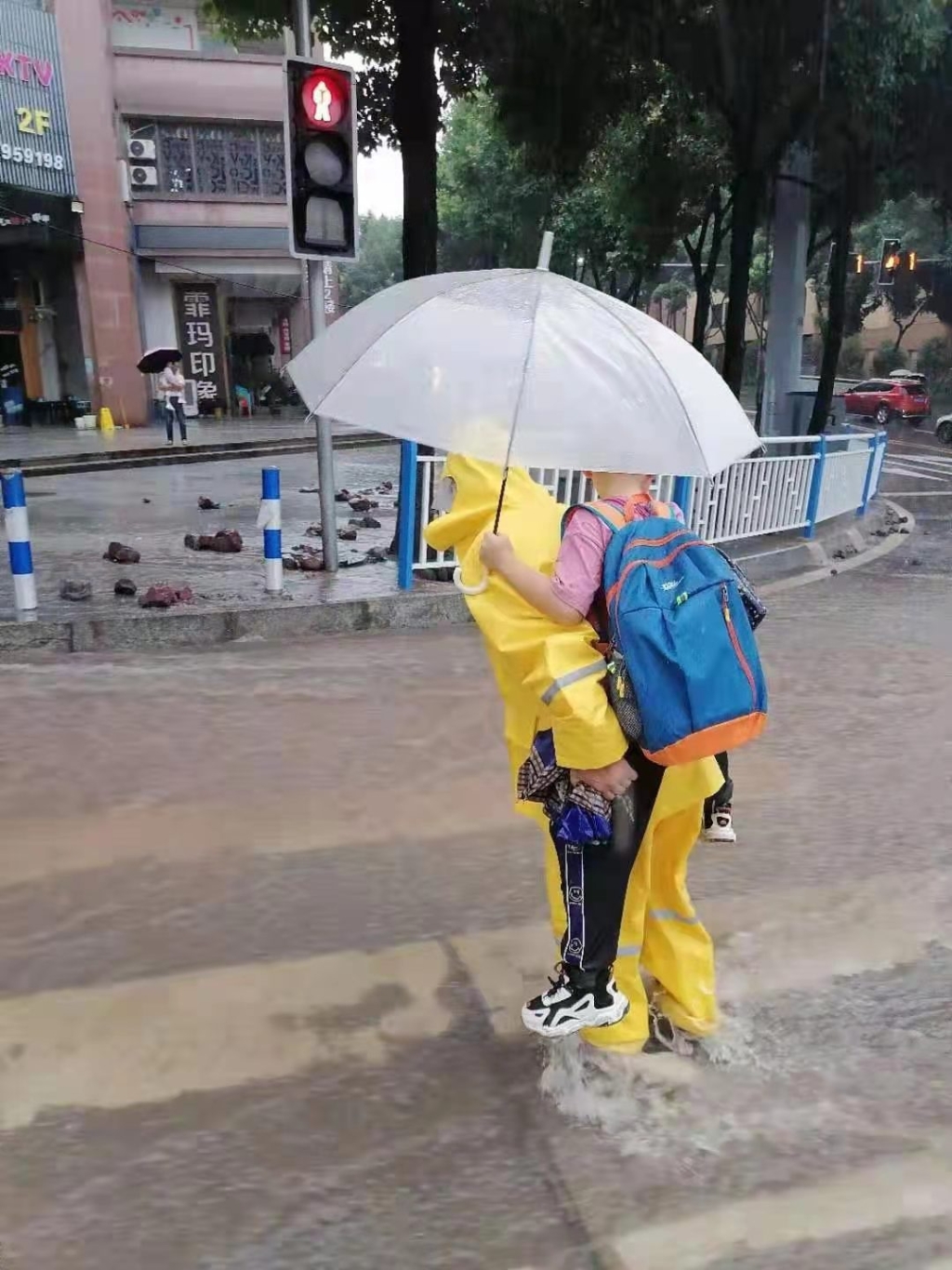 排水工作人员背小朋友过街 市住房城乡建委供图 华龙网-新重庆客户端 发