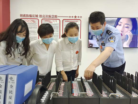 社区民警为群众介绍如何识别电诈设备。九龙坡警方供图 华龙网-新重庆客户端发