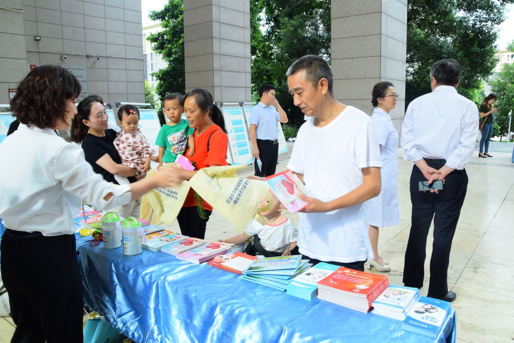 工作人员向市民发放科普资料。重庆市出生缺陷防治管理中心供图