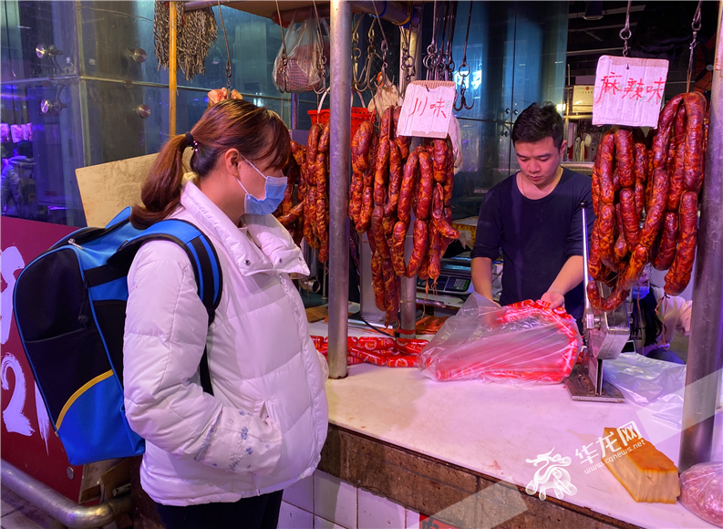 猪肉商户正在给市民灌制香肠。 华龙网-新重庆客户端记者  刘钊 摄 