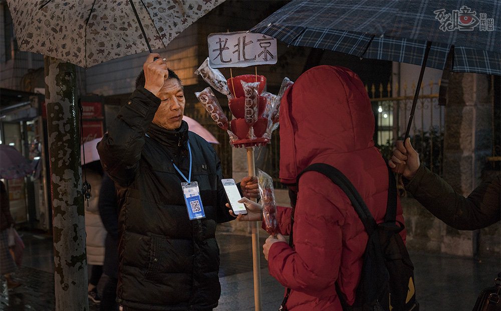 在渝中区重庆医学院路，一个大学生选好了一串糖葫芦，正要付钱的时候，卖糖葫芦的老人露出了挂在胸前的支付码。下雨天可以彻底“解放双手”，一码搞定。