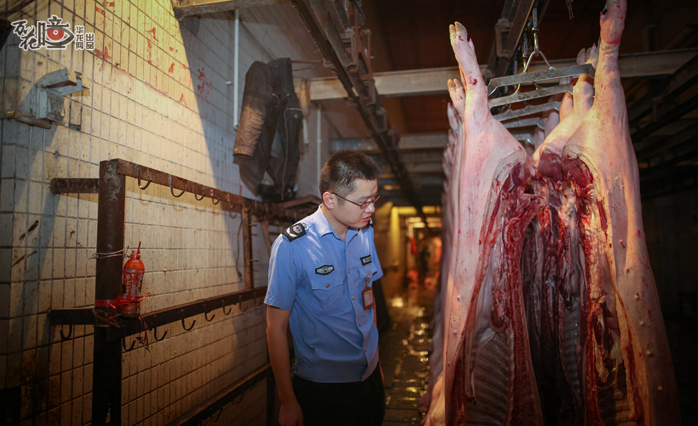 凌晨3点，一名动检工作人员巡查等候区，转身查看猪肉情况。