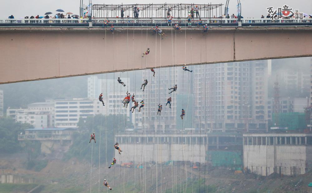勇敢者的游戏！在18日上午开始的正式赛比试中，200米落差的武隆乌江人行天桥上演绝地速降。