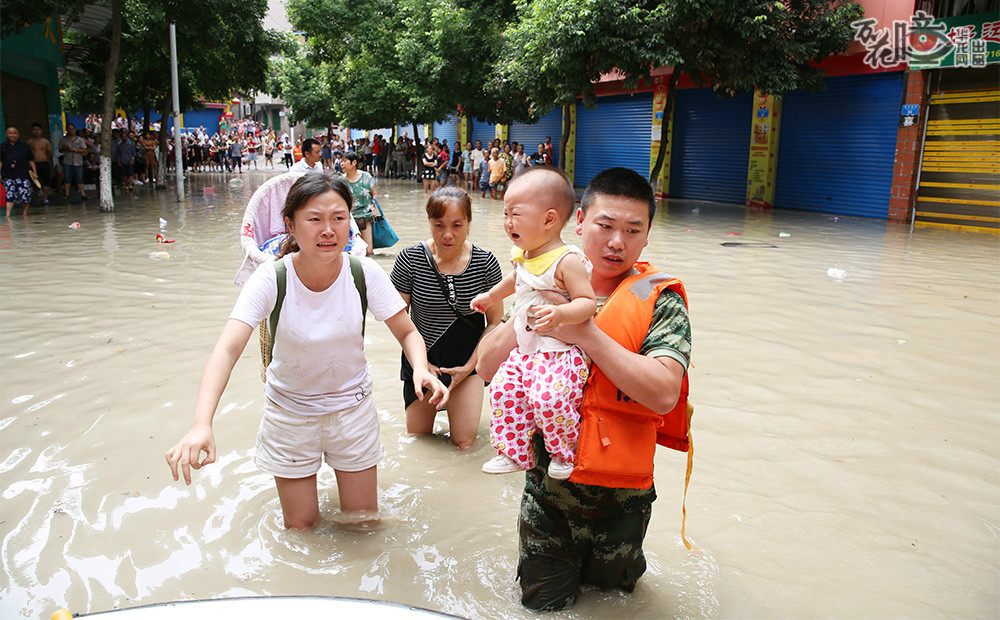 洪水无情人有情，被洪水所困的群众在民兵和志愿者的帮助下陆续转移。忙碌的救援现场，民兵、志愿者们背起行动不便的老人、抱起襁褓中的孩子，扶起需要帮助的群众。记者 刘嵩 摄