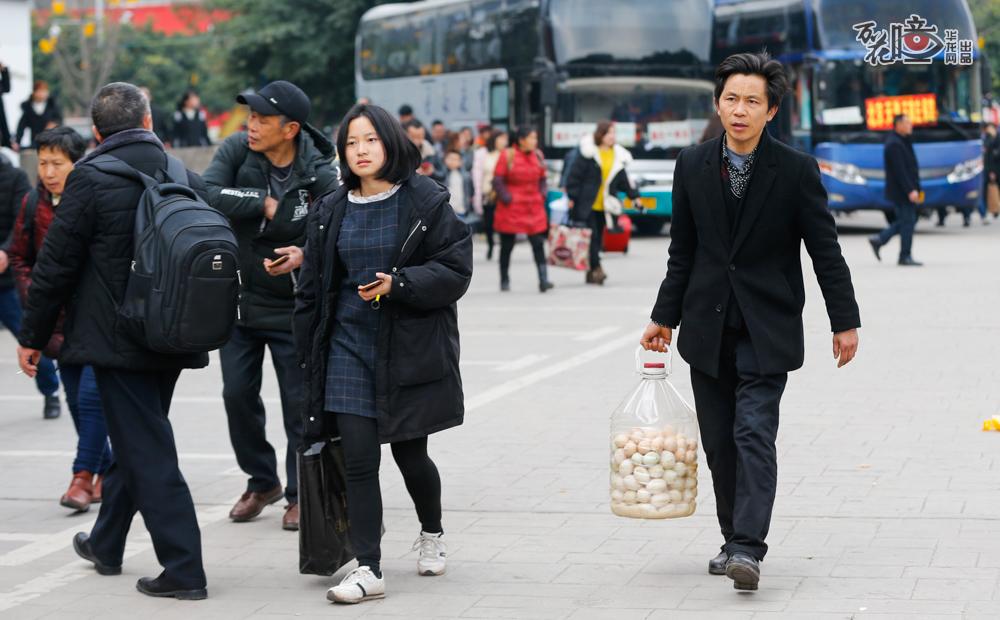 2月12日，重庆北站南广场汽车站，老王拎着沉甸甸的一桶蛋陪女儿出发去贵州铜仁。女儿今年读大三，这是头一次坐大巴车去学校报到。100多个鸡、鸭、鹅蛋，包含着父亲满满的牵挂和爱。