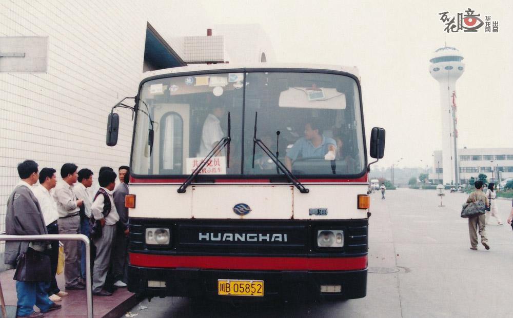 1995年，江北机场航站楼前的机场大巴正在转载乘客，从那时起，机场大巴成为了旅客往返机场到市区的主要交通工具。