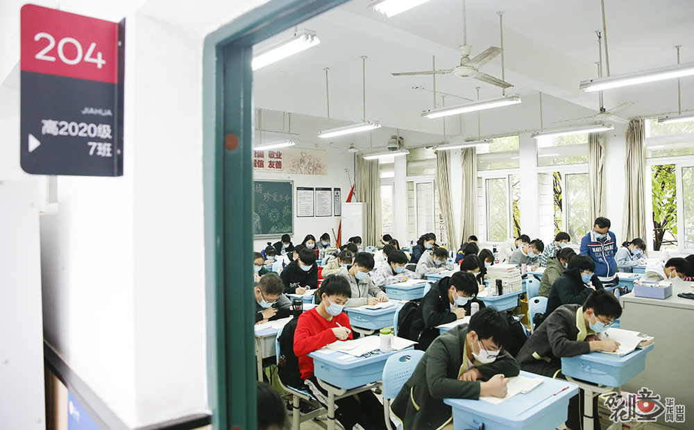 位于两江新区的礼嘉中学，学生们戴好口罩，全神贯注地“刷题”，老师在一旁帮助同学解答不会的习题。