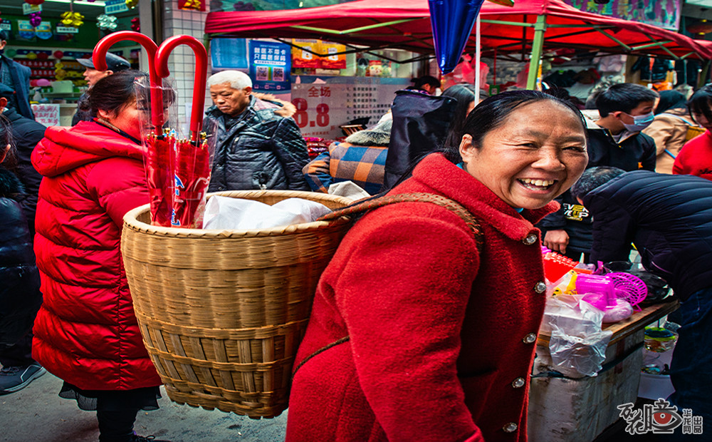 村民杨芬一大早就到溶溪镇赶场，背篓是购买的年货。春节她备的年货有肉禽果蔬，还有两把漂亮的红色雨伞，这是给孙女的新年礼物。