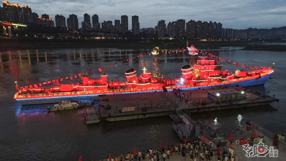 晚上八点，重庆九龙坡区建设码头华灯初上，166舰主题灯光被点亮，一瞬间，整个舰体变成了红色。
