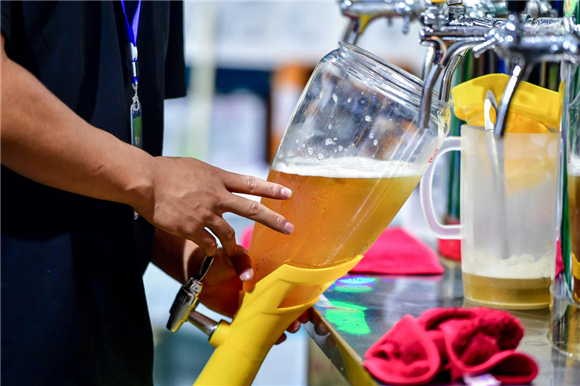 工作人员正在为游客接啤酒.