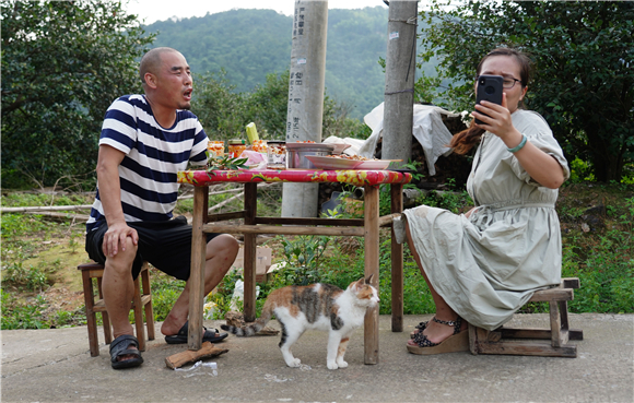 新华社记者 周密 摄7月2日,蒋金春(右)和母亲李嫦娥一起直播制作美食.