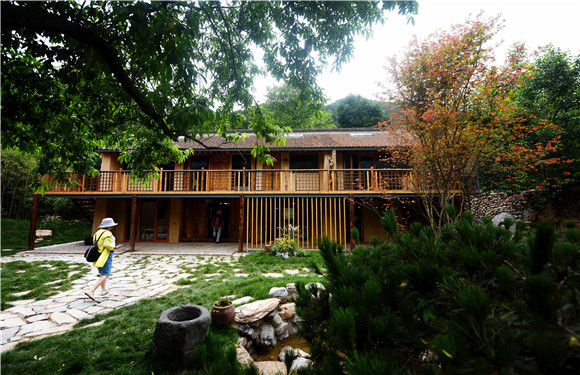 游客在陕西太白县咀头镇白云村即将运营的民宿内参观.